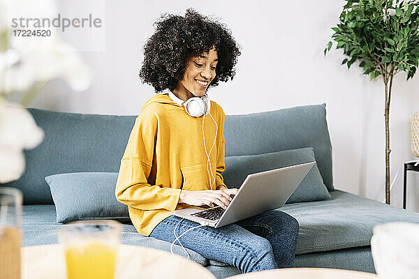 Junge Frau benutzt Laptop zu Hause