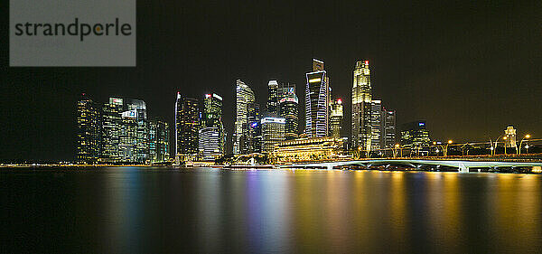Singapur  Langzeitbelichtung der Marina Bay bei Nacht mit Jubilee Bridge und Wolkenkratzern im Hintergrund