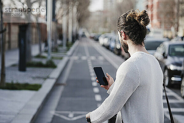 Mann benutzt Smartphone auf der Straße