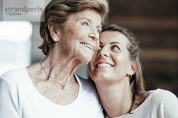 Lächelnde Frau betrachtet nachdenkliche Großmutter zu Hause