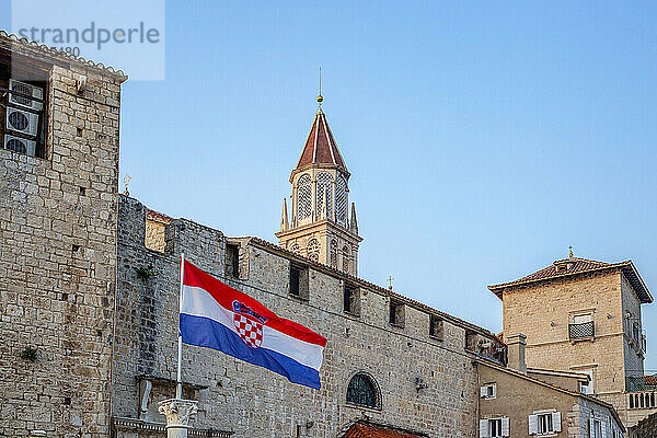 Kroatien  Gespanschaft Split-Dalmatien  Trogir  kroatische Flagge vor alten Stadthäusern mit Glockenturm der Kirche des Heiligen Nikolaus im Hintergrund