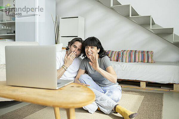 Reifes Paar gestikuliert während eines Videoanrufs auf dem Laptop zu Hause