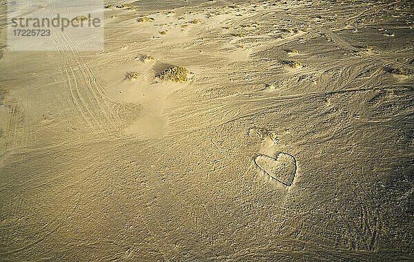 Spanien  Kanarische Inseln  Fuerteventura  Luftaufnahme der Herzform aus Steinen am Sandstrand Playa de Cofete bei Sonnenuntergang
