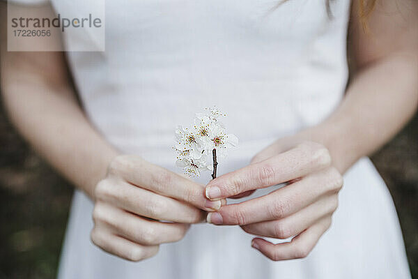 Frau hält weiße Blumen