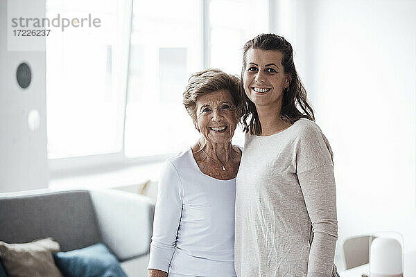 Glückliche ältere Frau mit Enkelin  die zusammen zu Hause stehen