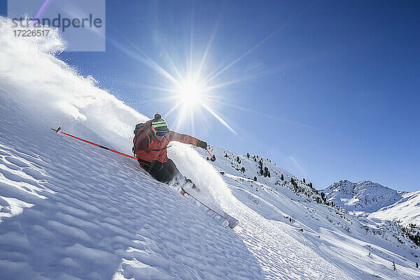 Sonnenschein über einem Mann beim Skifahren im Arlberg-Massiv
