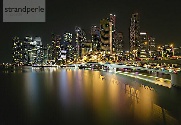 Singapur  Langzeitbelichtung der Marina Bay bei Nacht mit Jubilee Bridge und Wolkenkratzern im Hintergrund