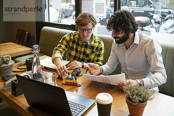 Geschäftsleute diskutieren bei der Arbeit in einem Coworking-Büro über ein 3D-Druck-Spiel