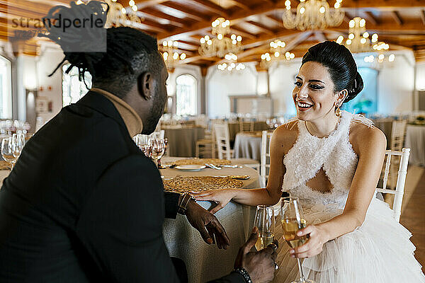 Schöne Frau und reifer Mann sitzen am Tisch und halten Champagner beim Bankett
