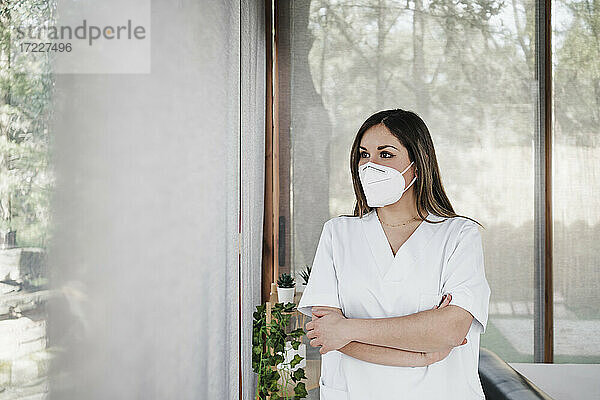 Ärztin mit Gesichtsschutzmaske träumt im Krankenhaus