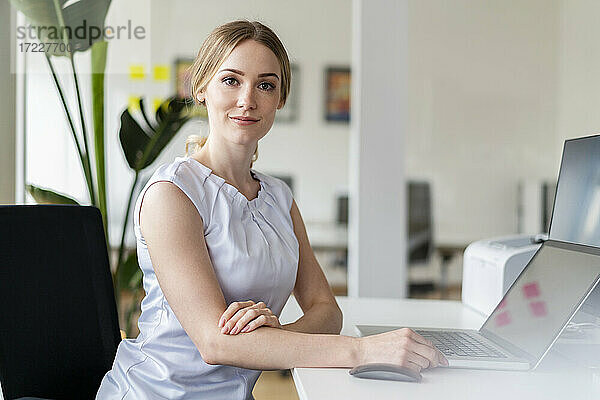 Weibliche Fachkraft sitzt vor einem Laptop im Büro
