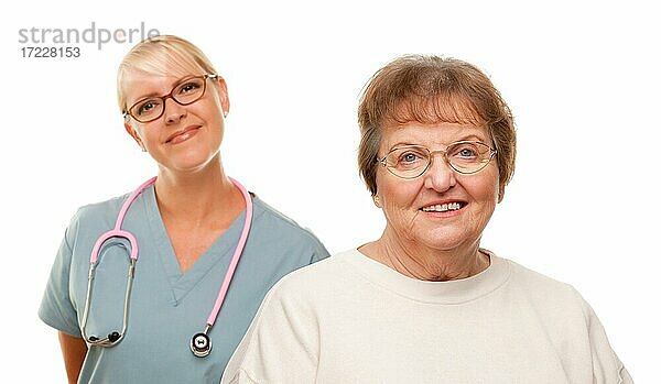 Lächelnde ältere Frau mit weiblichen Arzt hinter isoliert auf einem weißen Hintergrund