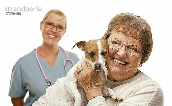 Glückliche ältere Frau mit ihrem Hund und Tierarzt hinter isoliert auf einem weißen Hintergrund