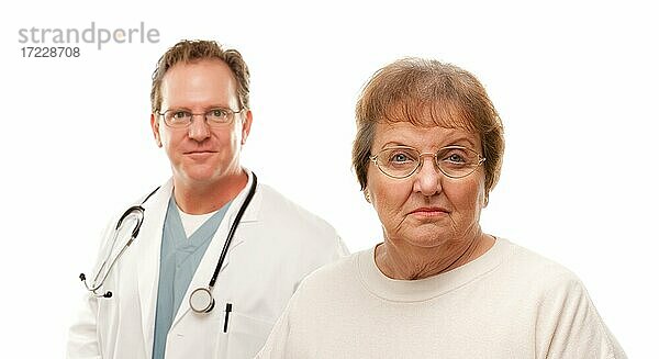 Besorgte ältere Frau mit männlichen Arzt hinter isoliert auf einem weißen Hintergrund