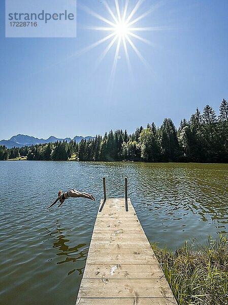 Junge Frau macht einen Kopfsprung in einen See  Geroldsee  Mittenwald  Karwendel  Bayern  Deutschland  Europa