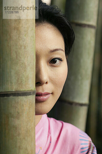 Close up Porträt schöne junge asiatische Frau hinter Bambus