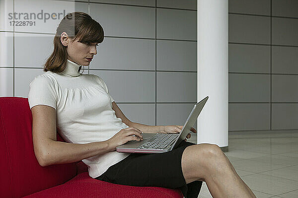 Geschäftsfrau mit Laptop in der Büro-Lobby