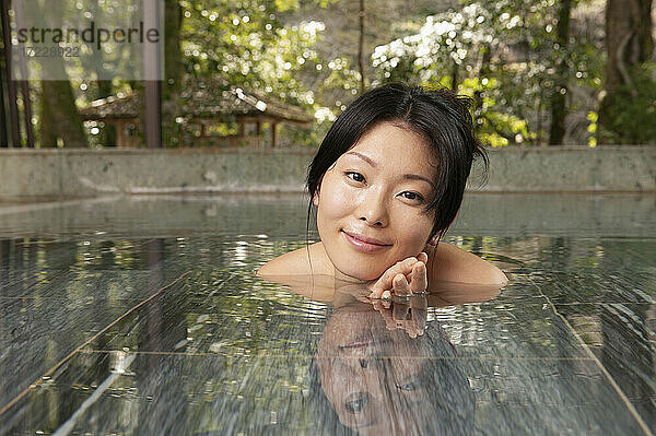 Porträt schöne junge Frau Einweichen im Pool bei ruhigen Onsen