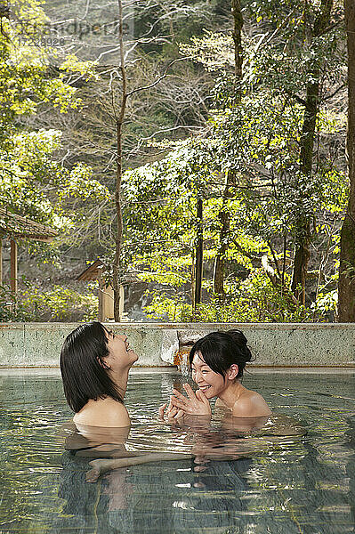 Glückliche junge Frauen Freunde Einweichen im Pool bei Onsen