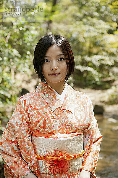 Porträt schöne junge Frau in orange Kimono