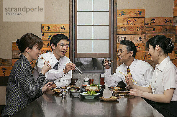 Japanische Geschäftsleute beim Mittagessen am Restauranttisch