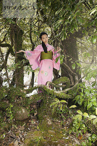 Porträt schöne junge Frau in rosa Kimono unter Baum