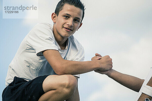 Porträt zuversichtlich Teenager Junge hält Hände mit Freund