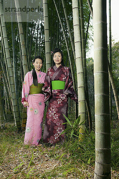 Porträt schöne junge Frauen in japanischen Kimonos unter Bambusbäumen