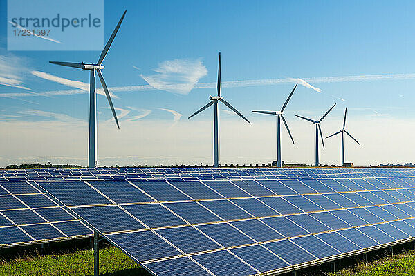 Windturbinen-Energieerzeuger in einem Windpark  mit darunter liegenden Solarzellen.