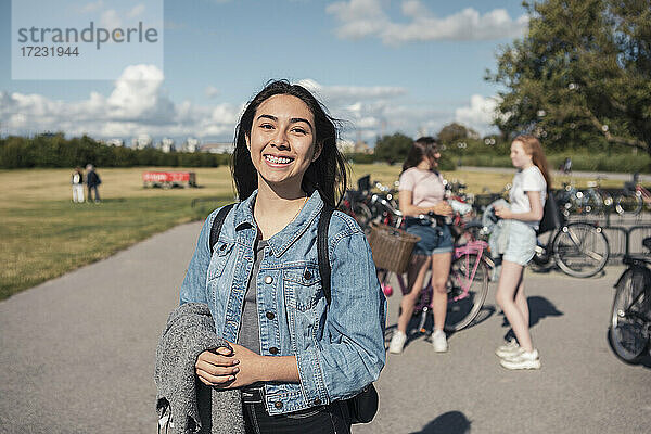 Porträt eines lächelnden Teenager-Mädchens im Park an einem sonnigen Tag