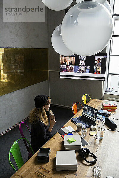 Hohe Winkel Ansicht der Geschäftsfrau zeigt Produkt an Kunden während der Sitzung auf Web-Konferenz
