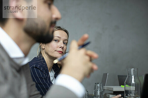 Geschäftsfrau mit männlichem Kollegen im Gespräch während eines Treffens im Kreativbüro