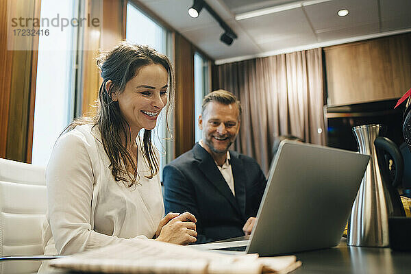 Lächelnd männlichen und weiblichen Anwalt diskutieren über Laptop im Büro