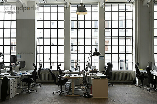 Interieur eines kreativen Büros mit Schreibtischen und Stuhl