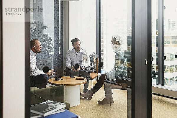 Männliche Unternehmer planen Strategie während eines Meetings durch die Tür gesehen Büro