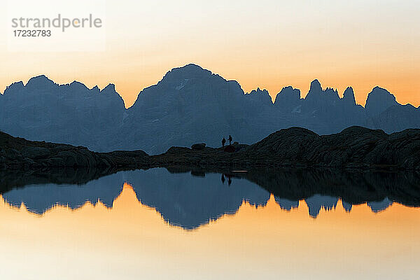 Brenta-Dolomiten Berge spiegeln sich im unberührten Wasser des Lago Nero di Cornisello bei Sonnenaufgang  Trentino-Südtirol  Italien  Europa