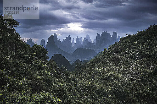 Yangshuo Berge mit dunklen Wolken umrahmt von Hügeln  Yangshuo  Guangxi  China  Asien