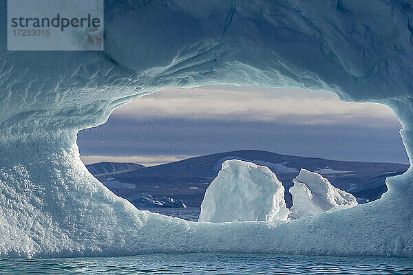 Ein Loch in einem Eisberg im De Dodes Fjord (Fjord der Toten)  Baffin Bay  Grönland  Polarregionen