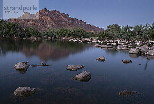 Blaue Stunde in einer Oase im Draa-Tal mit einem ruhigen Teich und einem Berg im Hintergrund  Draa-Tal  Marokko  Nordafrika  Afrika