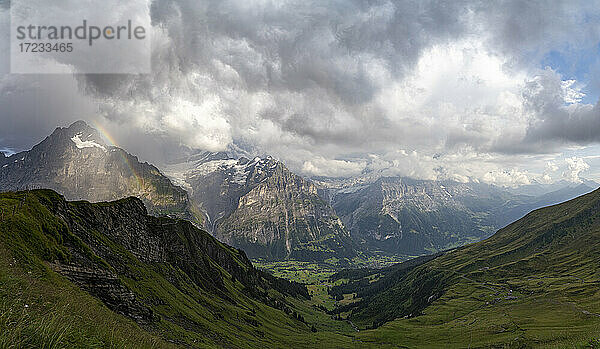 Panoramablick auf grünes Tal um Grindelwald und Berner Alpen beleuchtet von Regenbogen  First  Kanton Bern  Schweiz  Europa
