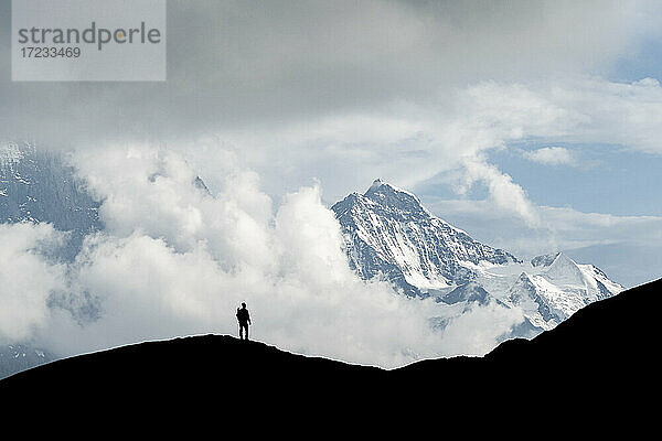 Silhouette von Wanderer Mann bewundern Jungfrau Berggipfel von First  Grindelwald  Berner Alpen  Kanton Bern  Schweiz  Europa