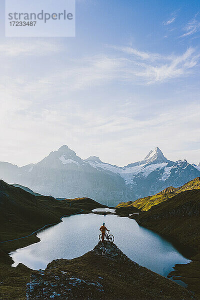 Mountainbiker mit Blick auf den Bachalpsee und die Berge des Berner Oberlandes in der Morgendämmerung  Grindelwald  Kanton Bern  Schweiz  Europa