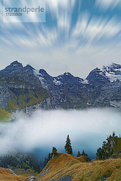 Wolken am Himmel über dem nebelverhangenen Oeschinensee  Berner Oberland  Kandersteg  Kanton Bern  Schweiz  Europa