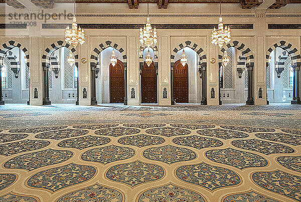 Männlicher Gebetsraum der Sultan-Qaboos-Moschee mit dekoriertem Teppich und vielen Bögen  Muscat  Oman  Naher Osten