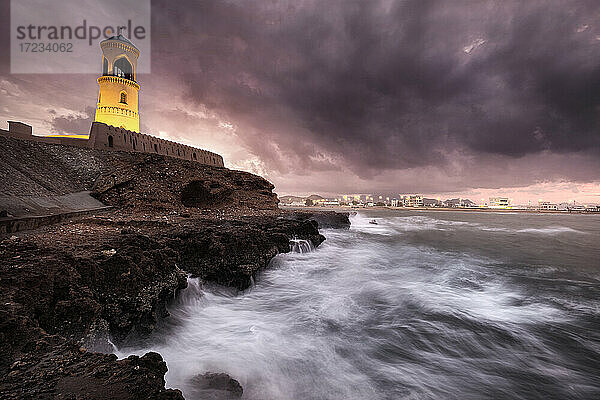 Sur Leuchtturm mit dem stürmischen Meer auf der Klippe und einem rosa Sonnenuntergang  Sur  Oman  Naher Osten