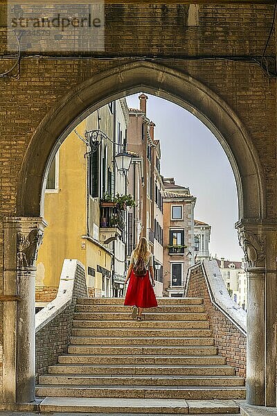 Junge Frau mit rotem Rock auf Treppe  Torbogen  Mercato di Rialto  Venedig  Venetien  Italien  Europa