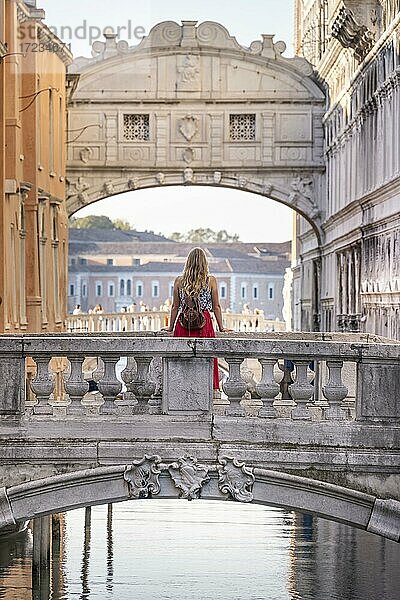 Junge Frau mit rotem Rock  Touristin lehnt an Brückengeländer  Brücke über dem Rio di Palazzo  hinten Seufzerbrücke  Venedig  Venetien  Italien  Europa
