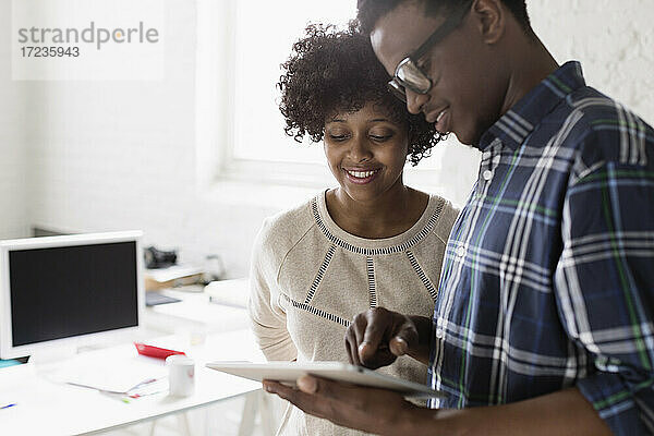 Junger Mann und Frau mit digitalem Tablet