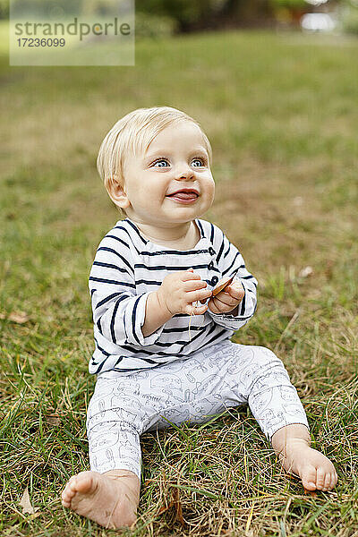 Porträt von Baby Mädchen sitzt auf Gras  lächelnd