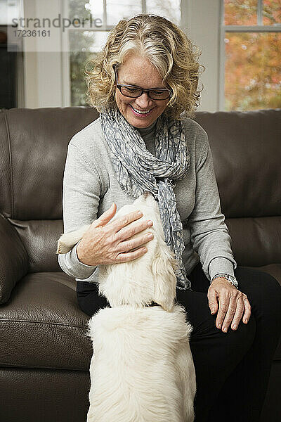 Seniorin mit Hund im Wohnzimmer